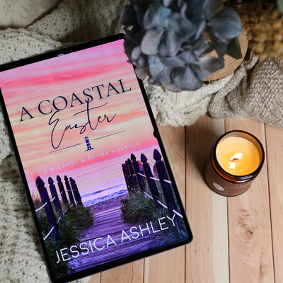 Book cover for 'A Coastal Easter' by Jessica Ashley, styled on a wooden surface next to a lit 'Cinnamon Orange Clover' candle and a cozy knit blanket.